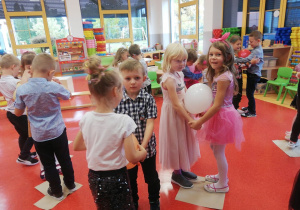 dzieci tańczą na gazetach z balonami
